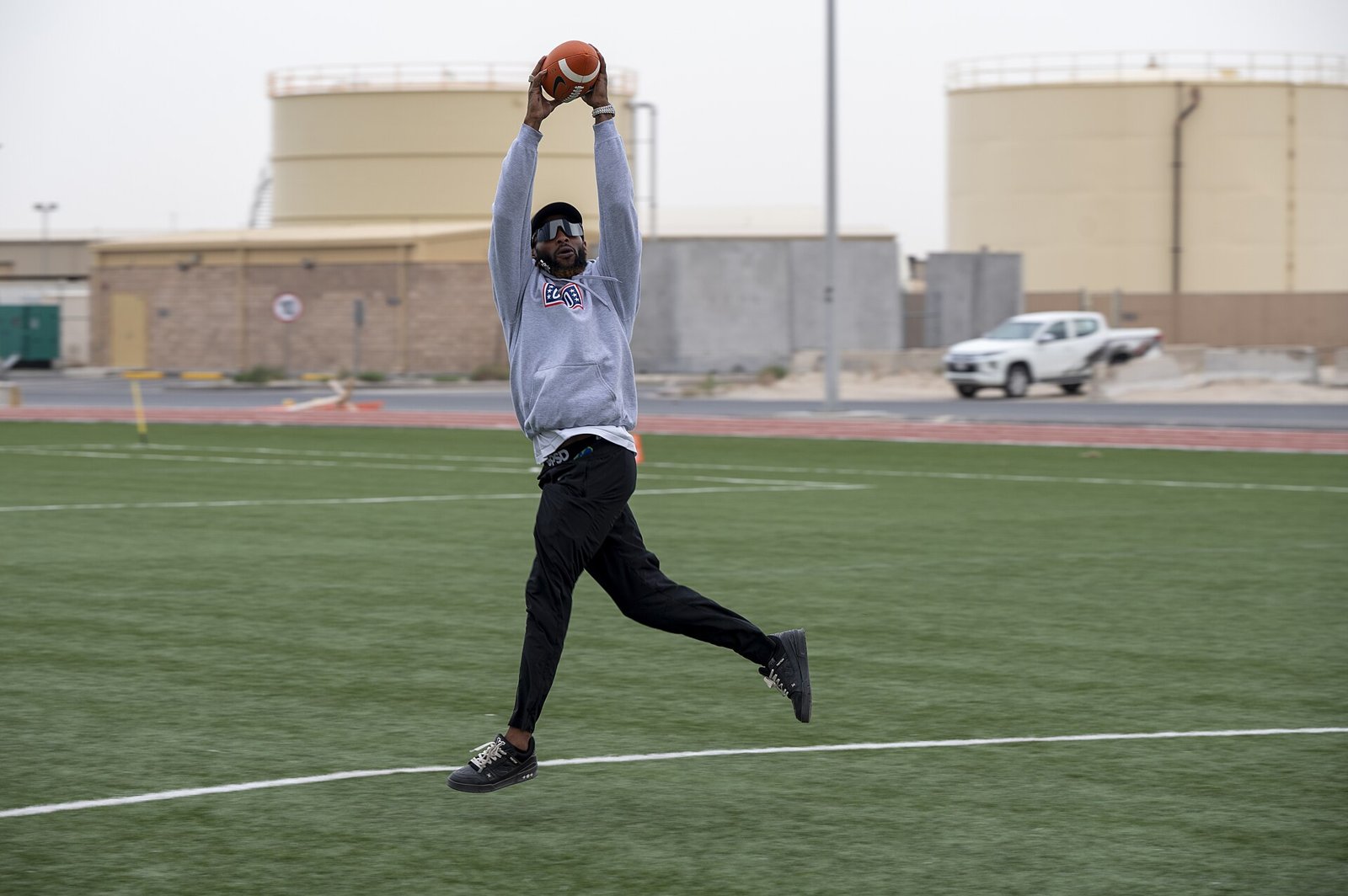 Aaron Jones Sr. catches a football during a USO visit in 2025