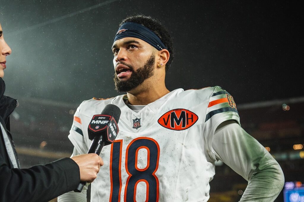 Bears quarterback Caleb Williams speaks into a microphone on the field after a game
