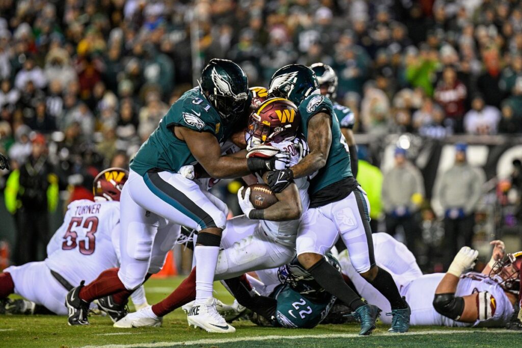 Eagles defenders, including Fletcher Cox, tackle a Washington Commanders ball carrier at Lincoln Financial Field on November 14, 2022