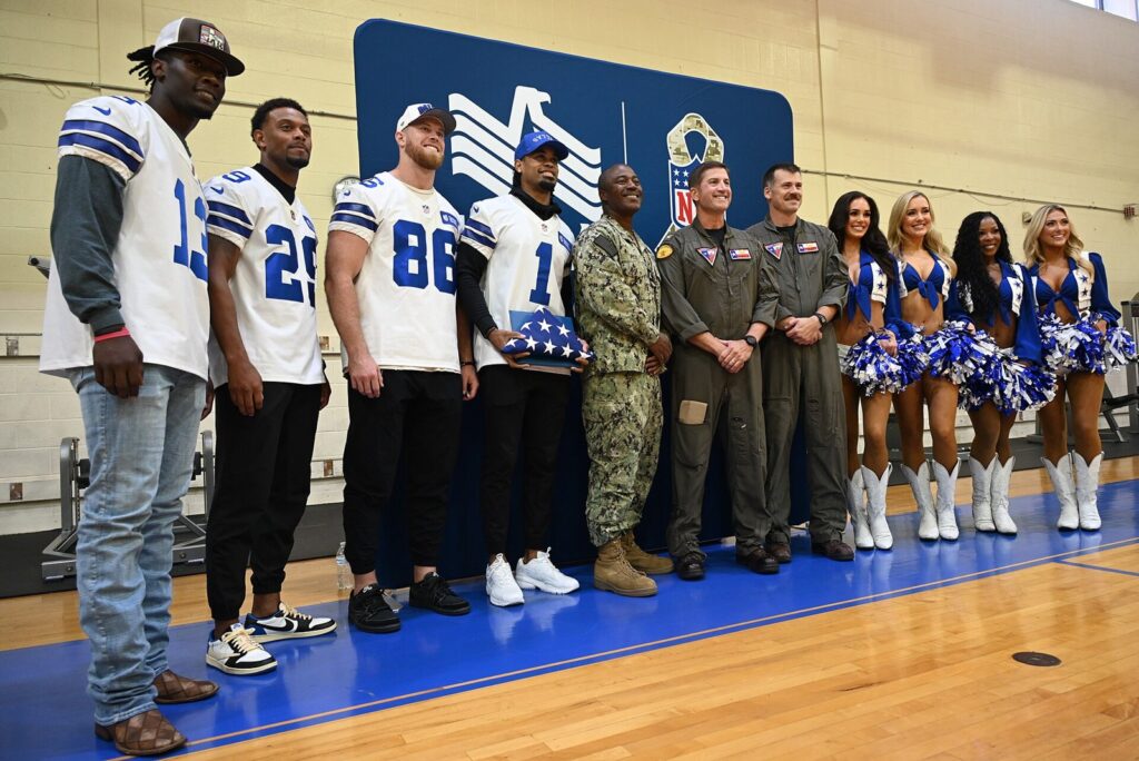 Dallas Cowboys players and cheerleaders pose with U.S. Navy leaders at a Salute to Service event