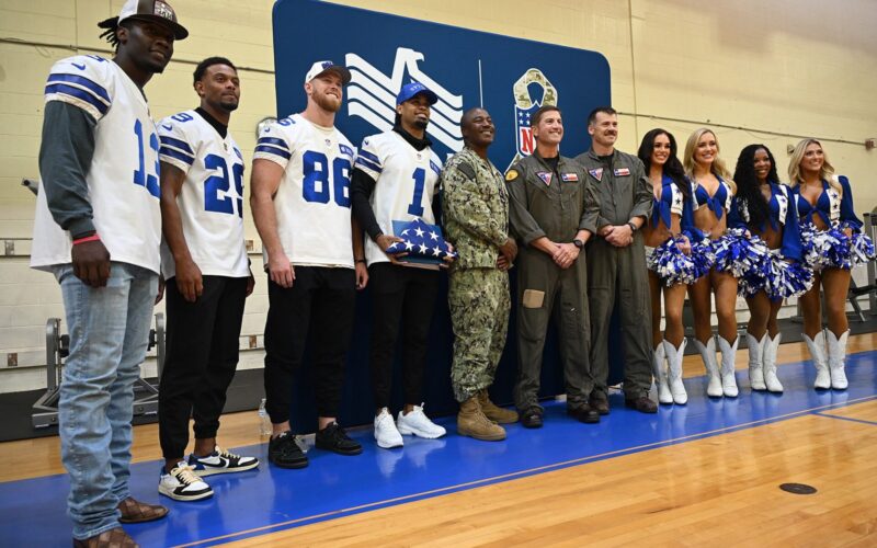 Dallas Cowboys players and cheerleaders pose with U.S. Navy leaders at a Salute to Service event