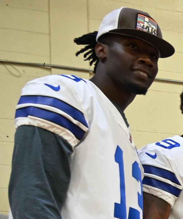 DeMarvion Overshown in a white Dallas Cowboys No. 13 jersey and a cap at a 2024 Salute to Service event