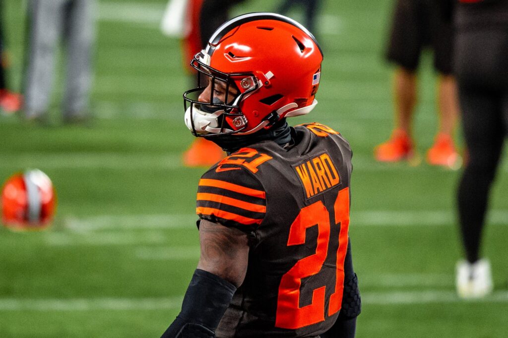 Denzel Ward in a brown Browns No. 21 color rush jersey and orange helmet on the field