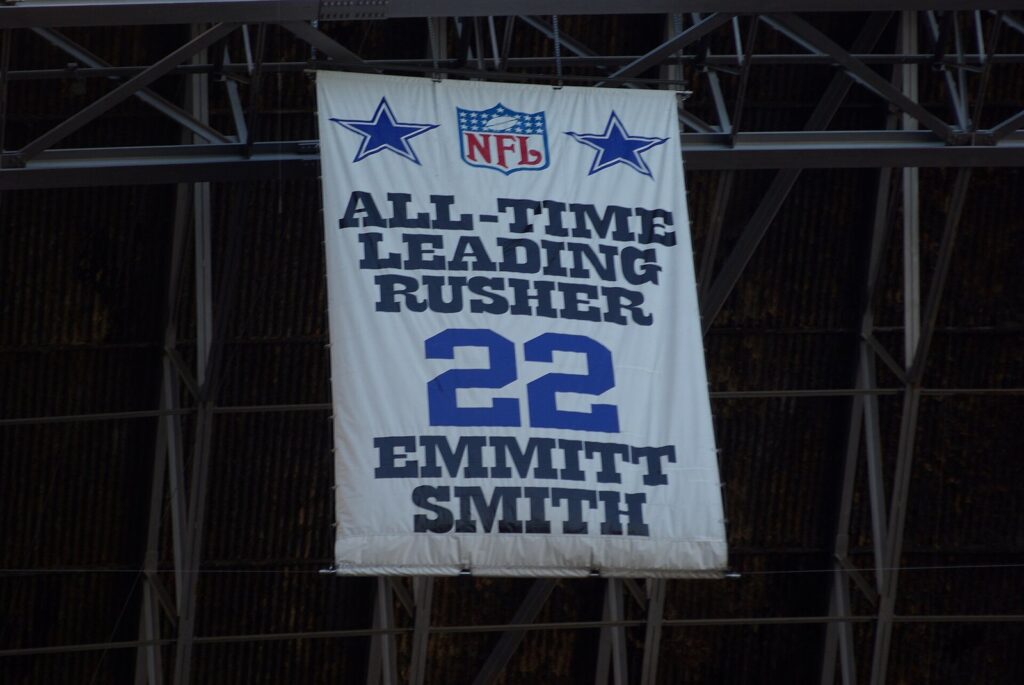 White banner reading All-Time Leading Rusher, 22, Emmitt Smith hanging from the roof trusses at Texas Stadium