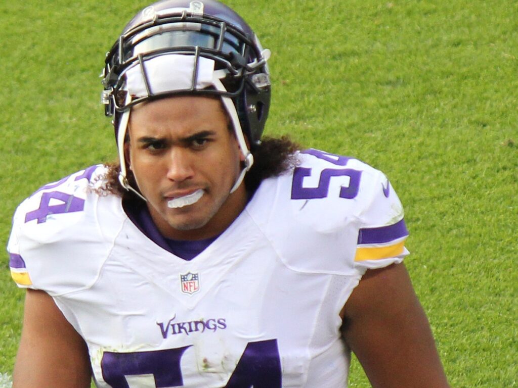 Eric Kendricks in a white Vikings No. 54 jersey walking on the field