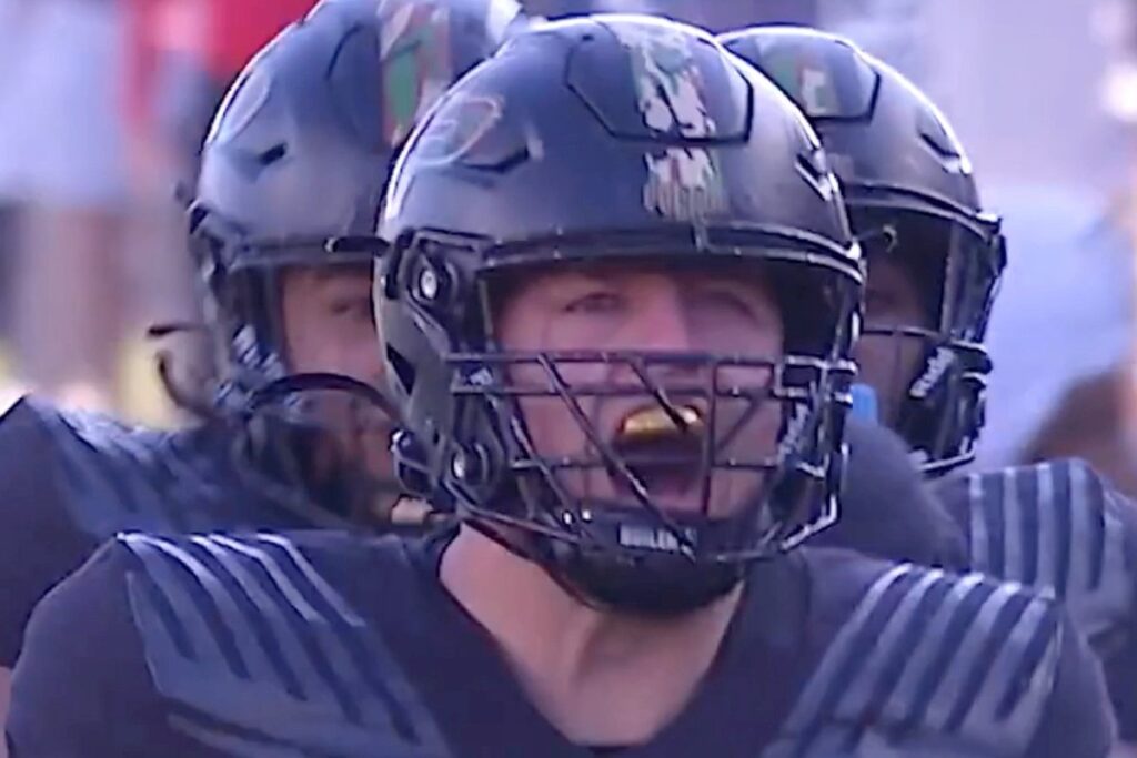 George Karlaftis in a black Purdue No. 5 uniform and helmet on the field
