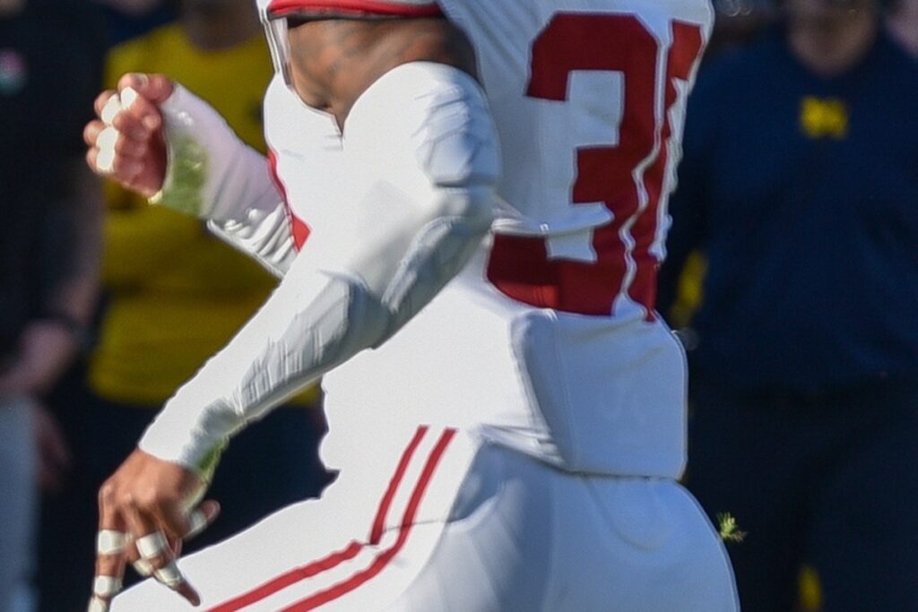 Jihaad Campbell in an Alabama crimson jersey and helmet looking downfield