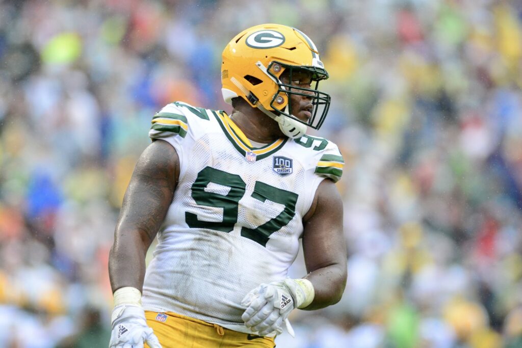 Kenny Clark in a white Green Bay Packers No. 97 jersey and gold helmet during a game