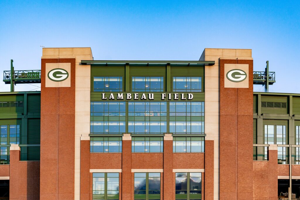 The brick facade of Lambeau Field in Green Bay, Wisconsin, with the stadium name and two Packers G logos.