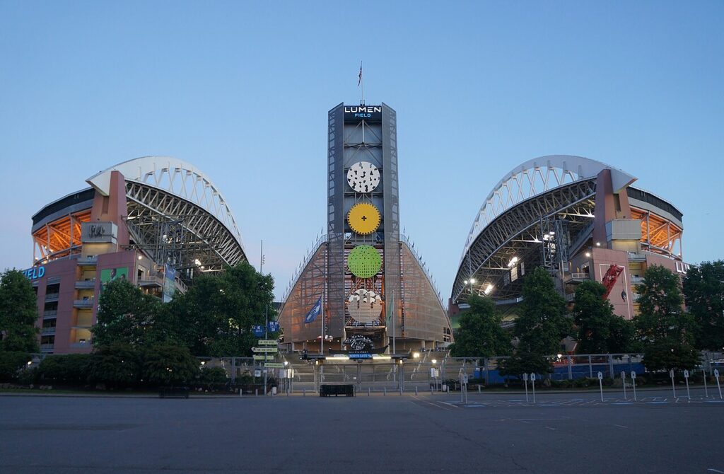 Lumen Field’s north entrance and illuminated roof supports at dusk in June 2022.