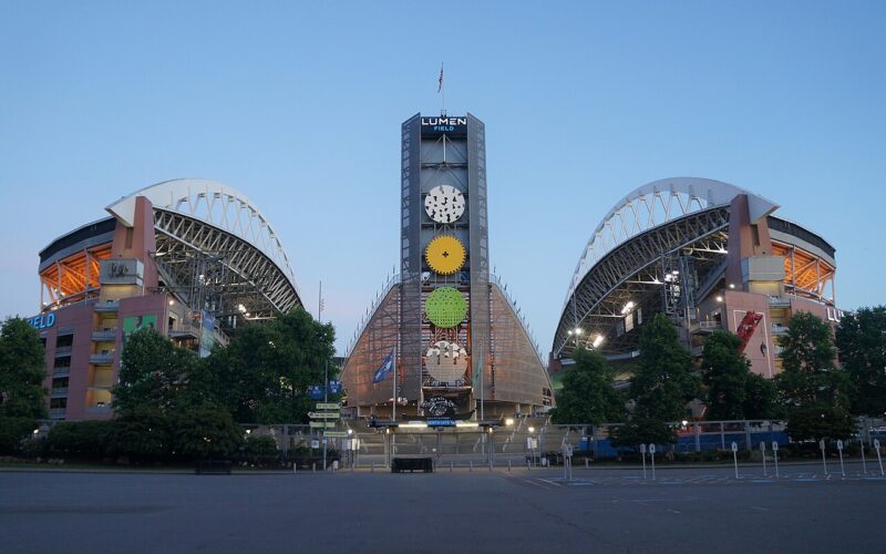 Lumen Field’s north entrance and illuminated roof supports at dusk in June 2022.