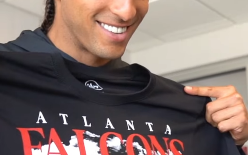 Mack Hollins wears a red beanie and holds an Atlanta Falcons shirt in an archival March 2023 image.
