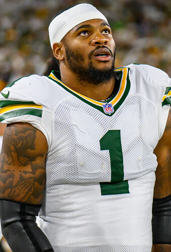 Micah Parsons in a white Green Bay Packers No. 1 jersey on the sideline at Lambeau Field