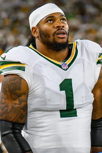 Micah Parsons in a white Green Bay Packers No. 1 jersey on the sideline at Lambeau Field