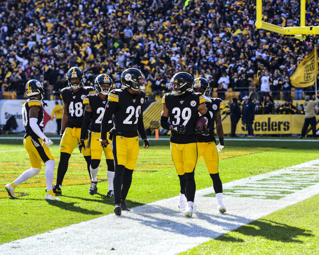 Minkah Fitzpatrick holds a football beside Steelers teammates after a touchdown in November 2019.