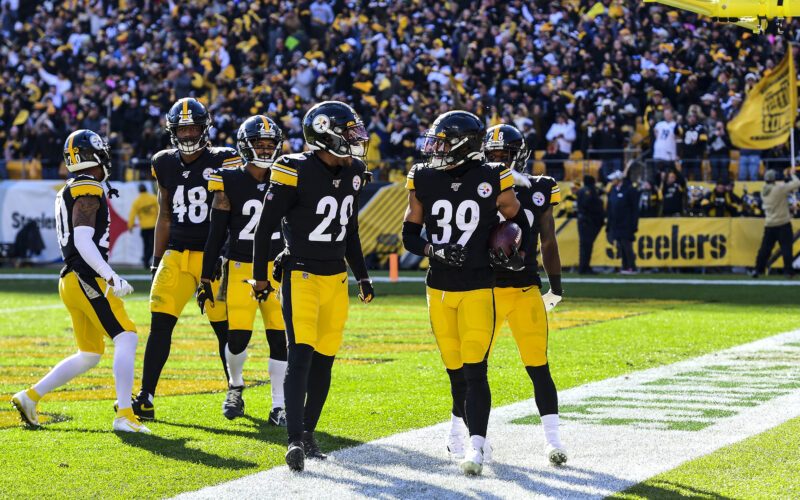 Minkah Fitzpatrick holds a football beside Steelers teammates after a touchdown in November 2019.
