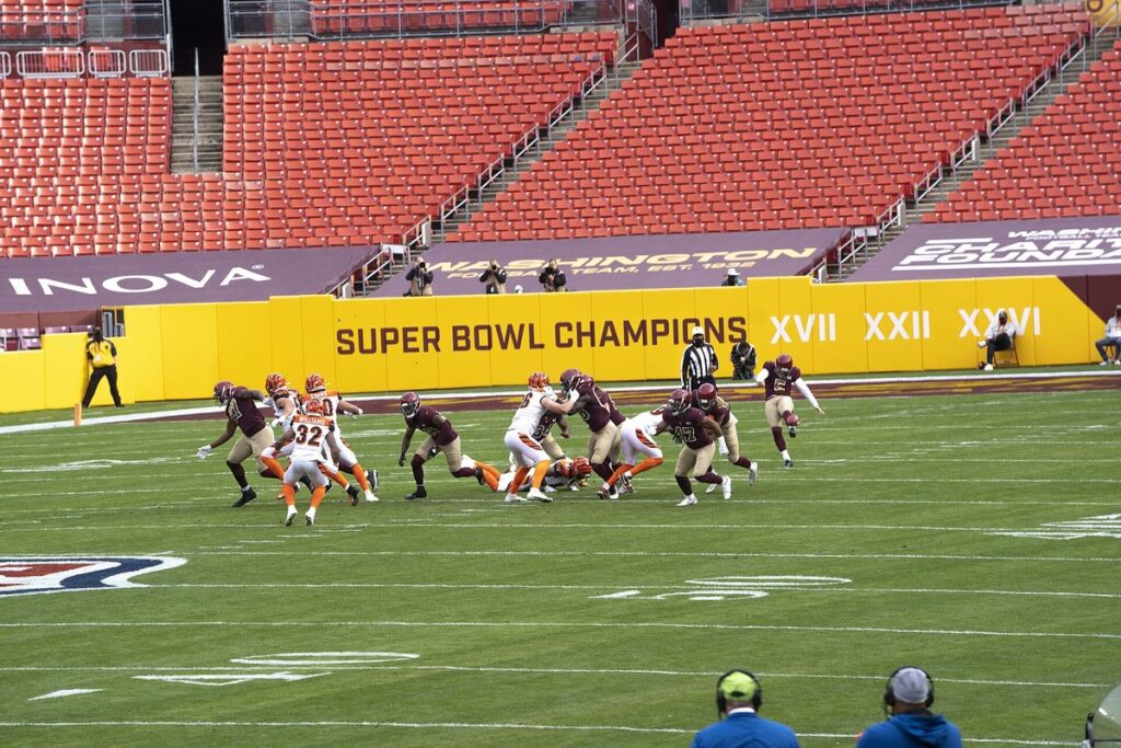 Washington punter Tress Way kicks the ball as the coverage team rushes downfield