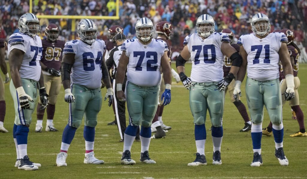 Dallas Cowboys offensive linemen engage Washington defenders at the line of scrimmage