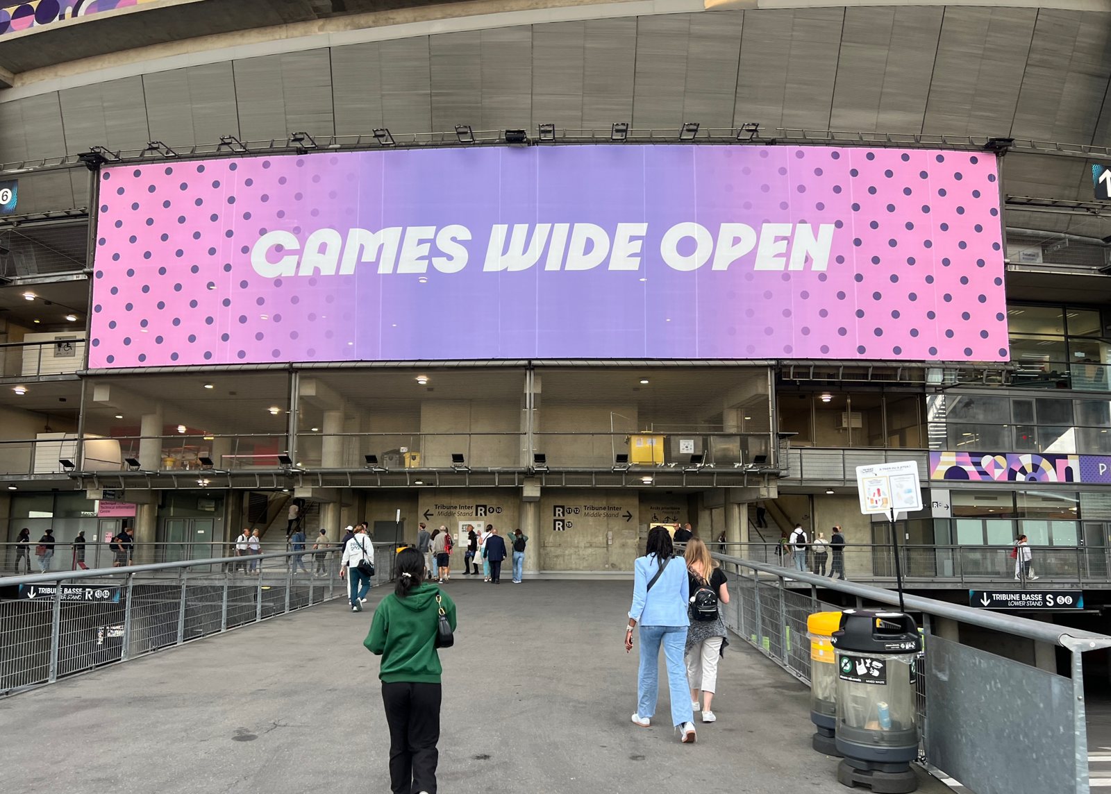 Fans walking up a ramp to an entrance of the Stade de France in Saint-Denis