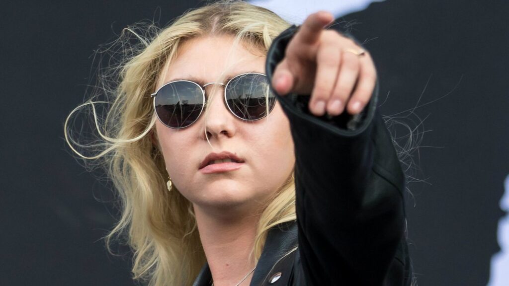 Taylor Momsen of The Pretty Reckless pointing toward the crowd on stage