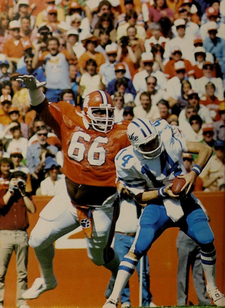 William Perry in an orange Clemson jersey, number 66, tackling Duke quarterback Ben Bennett in 1982