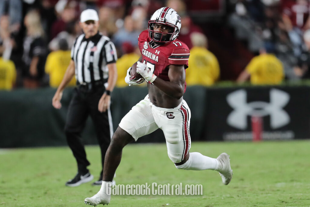 Xavier Legette runs with a football in South Carolina's garnet number 17 jersey and white helmet during a September 2023 game.