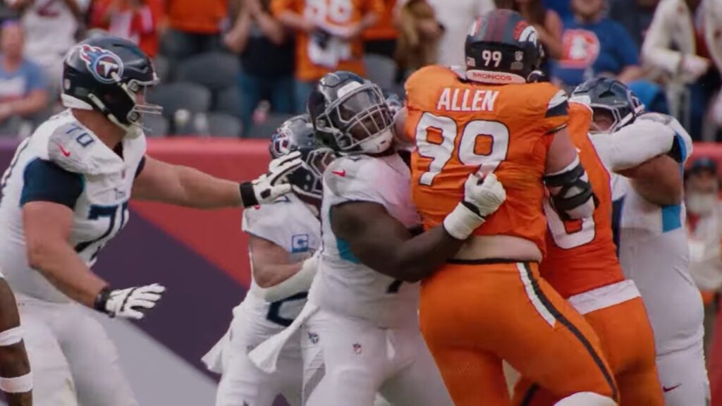 Zach Allen, No. 99 in an orange Broncos jersey, engaged with a Titans lineman